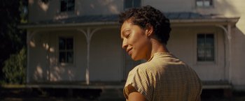Movie still from “Loving” (2016), directed by Jeff Nichols – A woman in a plaid shirt standing in front of a house; Close Up shot, Over the shoulder angle