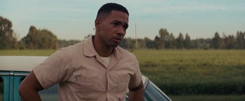 Movie still from “Loving” (2016), directed by Jeff Nichols – A man standing in front of a car in a grassy field; Close Up shot, Over the shoulder angle