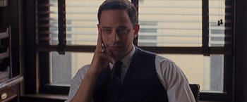 Movie still from “Loving” (2016), directed by Jeff Nichols – A man wearing a suit and tie holding a cell phone to his ear; Close Up shot, Over the shoulder angle