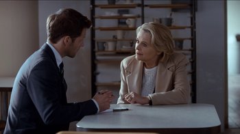 Movie still from “Marcella” (2016), created by Hans Rosenfeldt – A man and a woman sitting at a table talking to each other; Medium shot, Over the shoulder angle