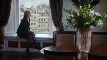 Movie still from “Marcella” (2016), created by Hans Rosenfeldt – A woman sitting in front of a large window looking outside; Wide shot, Over the shoulder angle
