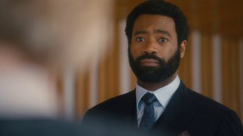 Movie still from “Marcella” (2016), created by Hans Rosenfeldt – A man with a beard wearing a suit; Close Up shot, Over the shoulder angle