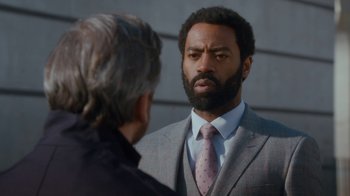Movie still from “Marcella” (2016), created by Hans Rosenfeldt – A man wearing a suit and tie talking to another man wearing a suit and tie; Close Up shot, Over the shoulder angle