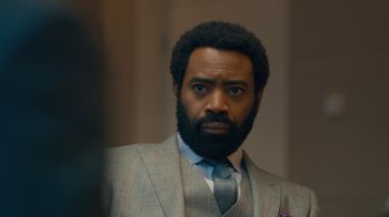 Movie still from “Marcella” (2016), created by Hans Rosenfeldt – A man in a suit and tie looking at the camera; Close Up shot, Over the shoulder angle