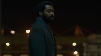 Movie still from “Marcella” (2016), created by Hans Rosenfeldt – A man standing in the dark with his head turned to the side; Close Up shot, Low angle