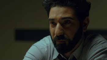 Movie still from “Marcella” (2016), created by Hans Rosenfeldt – A man with a goatee and a beard looking into the distance; Close Up shot, Over the shoulder angle