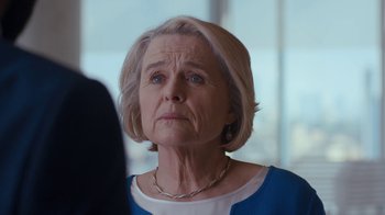 Movie still from “Marcella” (2016), created by Hans Rosenfeldt – An older woman with short blonde hair wearing a white and blue shirt; Close Up shot, Over the shoulder angle