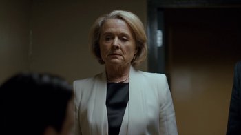 Movie still from “Marcella” (2016), created by Hans Rosenfeldt – An older woman wearing a white jacket and a black shirt; Close Up shot, Low angle