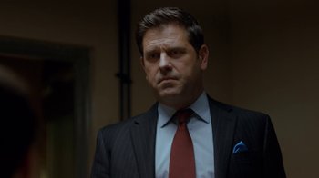 Movie still from “Marcella” (2016), created by Hans Rosenfeldt – A person wearing a suit and tie; Close Up shot, Over the shoulder angle