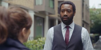 Movie still from “Marcella” (2016), created by Hans Rosenfeldt – A man wearing a vest and a red tie; Close Up shot, Over the shoulder angle