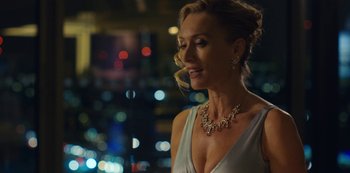 Movie still from “Marcella” (2016), created by Hans Rosenfeldt – A woman wearing a silver dress and a diamond necklace; Close Up shot, Over the shoulder angle