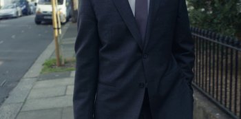 Movie still from “Marcella” (2016), created by Hans Rosenfeldt – A person wearing a suit and tie; Medium shot, High angle