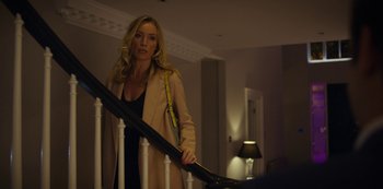 Movie still from “Marcella” (2016), created by Hans Rosenfeldt – A woman holding a black umbrella while standing on a staircase; Medium shot, Over the shoulder angle