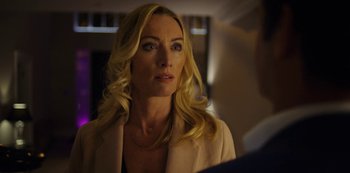 Movie still from “Marcella” (2016), created by Hans Rosenfeldt – A woman with blonde hair and a necklace looking to her left; Close Up shot, Over the shoulder angle