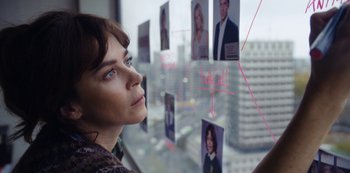 Movie still from “Marcella” (2016), created by Hans Rosenfeldt – A woman looking out of a window at a city; Close Up shot, High angle