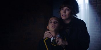 Movie still from “Marcella” (2016), created by Hans Rosenfeldt – A woman is helping a young boy with a tie; Close Up shot, Over the shoulder angle
