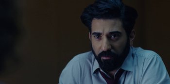 Movie still from “Marcella” (2016), created by Hans Rosenfeldt – A man with a beard wearing a white shirt and a red tie; Close Up shot, Over the shoulder angle
