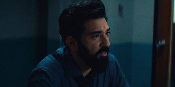 Movie still from “Marcella” (2016), created by Hans Rosenfeldt – A man with a beard is sitting in a room; Close Up shot, Over the shoulder angle