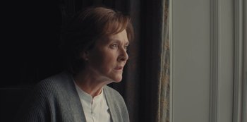 Movie still from “Marcella” (2016), created by Hans Rosenfeldt – An older woman looking out of a window; Close Up shot, Low angle