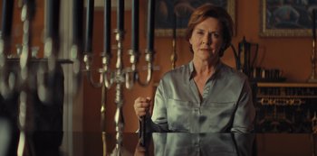 Movie still from “Marcella” (2016), created by Hans Rosenfeldt – A woman holding a pair of scissors in her hand; Medium shot, Low angle