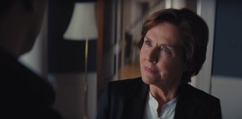 Movie still from “Marcella” (2016), created by Hans Rosenfeldt – An older woman wearing a black suit and white shirt; Close Up shot, Over the shoulder angle