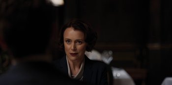 A woman in a black jacket is looking at the camera