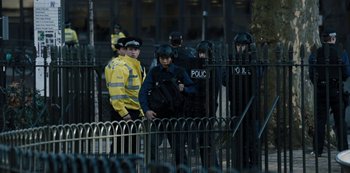 A group of police officers standing next to each other near a metal fence