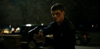 A man in a black shirt is holding a gun