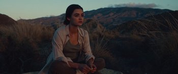 A woman sitting on the ground in the desert