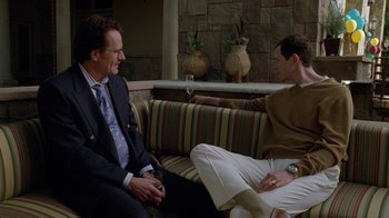 Movie still from “Breaking Bad” (2008), created by Vince Gilligan – Two men are sitting on a couch and talking to each other; Medium shot, Over the shoulder angle