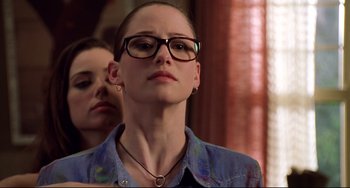 A woman wearing glasses and a jean jacket