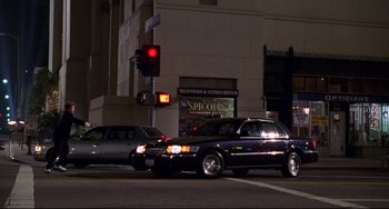 A car is stopped at a traffic light at night
