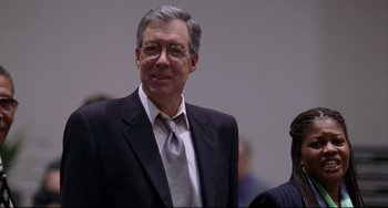 A man in a suit and tie standing next to another man