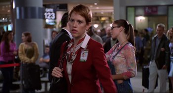 A woman in a red jacket is holding onto a purse