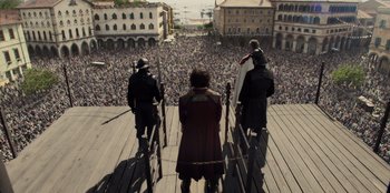 Movie still from “One Piece” (2023), directed by Marc Jobst – A group of people standing on top of a wooden platform; Extreme Wide shot, High angle