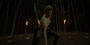 Movie still from “One Piece” (2023), directed by Marc Jobst – A man holding a sword in the woods at night; Medium shot, Low angle