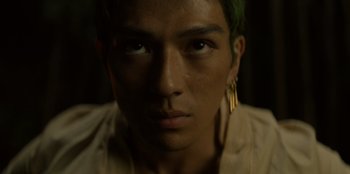 Movie still from “One Piece” (2023), directed by Marc Jobst – A person with green hair; Close Up shot, Low angle