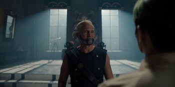 Movie still from “One Piece” (2023), directed by Marc Jobst – A man with a mouth guard on his face; Medium shot, Over the shoulder angle