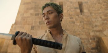 Movie still from “One Piece” (2023), directed by Marc Jobst – A man with green hair holding a baseball bat; Close Up shot, Low angle