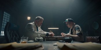 Movie still from “One Piece” (2023), directed by Marc Jobst – Two men sitting at a table playing a board game; Wide shot, Low angle