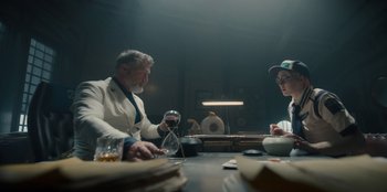 Movie still from “One Piece” (2023), directed by Marc Jobst – Two people sitting at a table with a glass of wine; Medium shot, Low angle