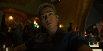 Movie still from “One Piece” (2023), directed by Marc Jobst – A man with green hair is taking a selfie; Close Up shot, Low angle