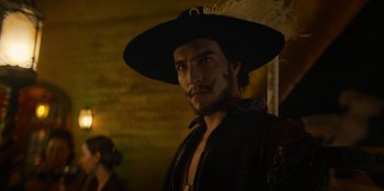 Movie still from “One Piece” (2023), directed by Marc Jobst – A man with a black hat is standing in a dark room; Close Up shot, Low angle