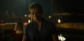 Movie still from “One Piece” (2023), directed by Marc Jobst – A man with green hair standing in the dark; Close Up shot, Low angle