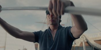 Movie still from “One Piece” (2023), directed by Marc Jobst – A man holding a sword in his hands; Close Up shot, Low angle