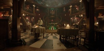 Movie still from “One Piece” (2023), directed by Marc Jobst – A man standing in front of a table in a room; Extreme Wide shot, High angle