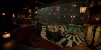 Movie still from “One Piece” (2023), directed by Marc Jobst – A group of people sitting around a table in a room; Wide shot, High angle