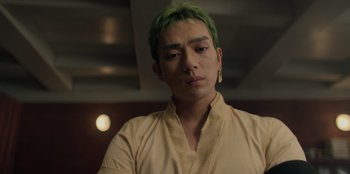 Movie still from “One Piece” (2023), directed by Marc Jobst – A man with green hair is looking at the camera; Close Up shot, Low angle