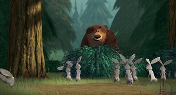 Movie still from “Open Season” (2006), directed by Roger Allers – A brown bear sitting on top of a pile of grass; Wide shot, Low angle