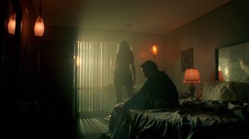 Movie still from “Breaking Bad” (2008), created by Vince Gilligan – A man sitting on a bed next to a woman in a bedroom; Wide shot, Low angle